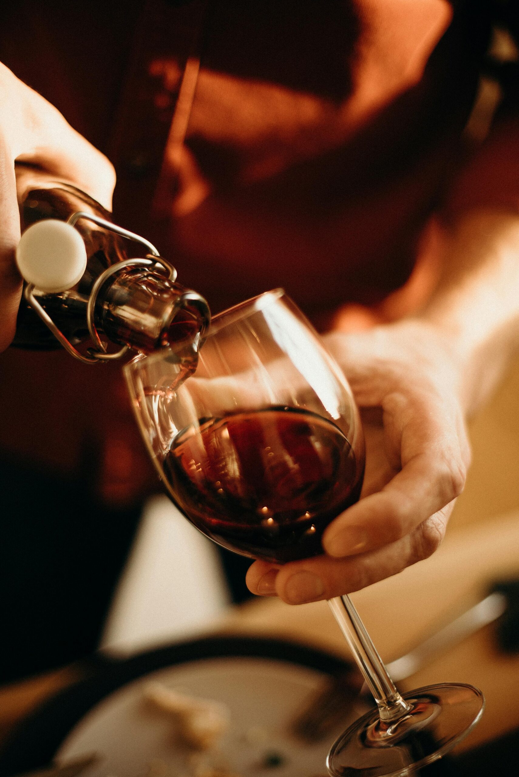 Close-up of pouring red wine into a glass, perfect for restaurant or romantic dinner themes.